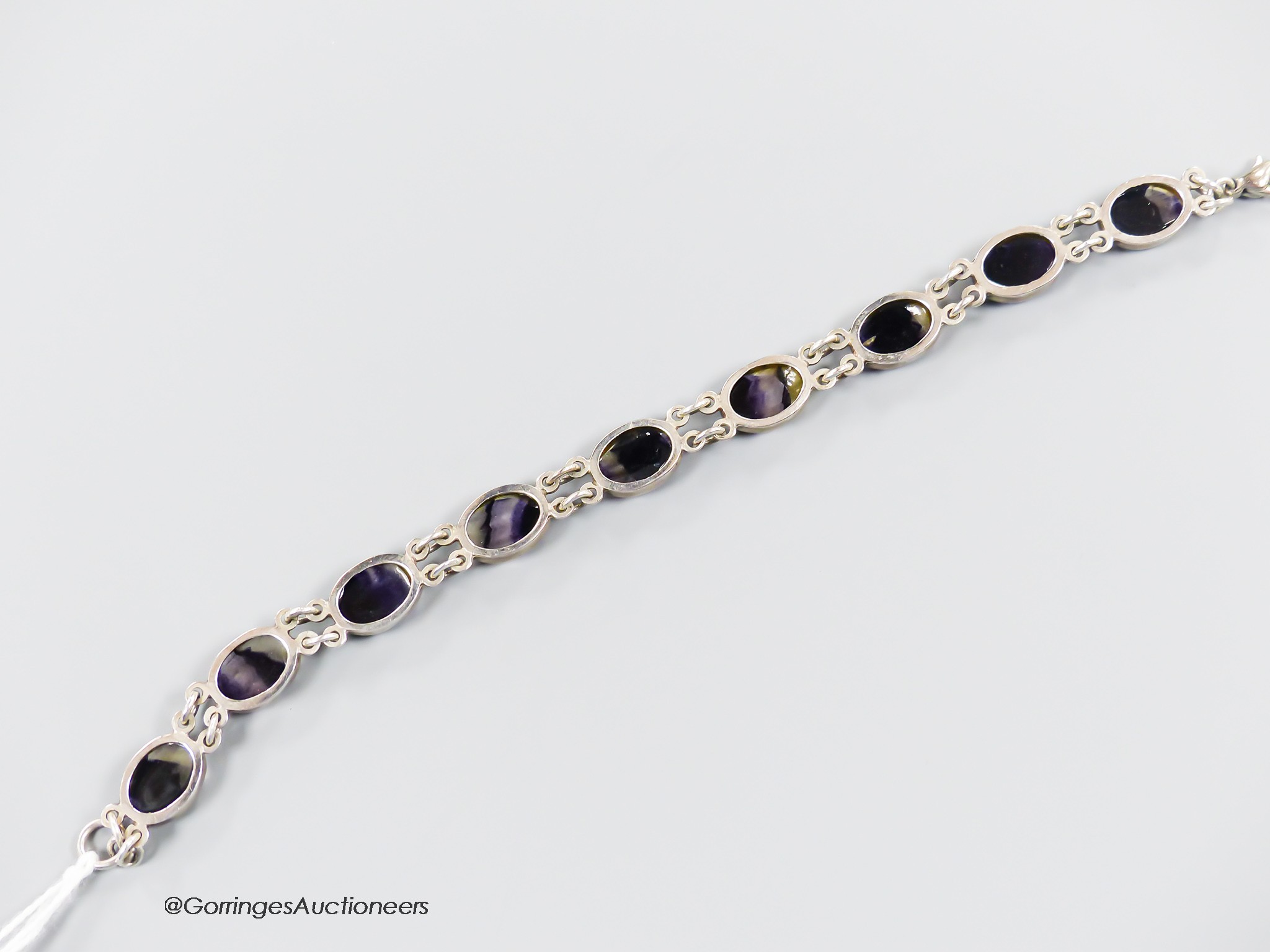 A white metal and nine stone cabochon blue john set bracelet, overall 19cm.